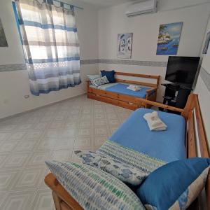 ein Schlafzimmer mit 2 Betten und einem TV in der Unterkunft Casa Raja in Gaeta