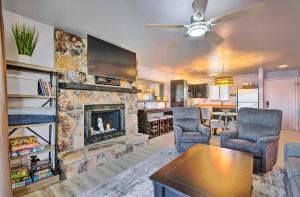 a living room with a stone fireplace and two chairs at Osage Beach Resort Condo with Community Pool! in Osage Beach