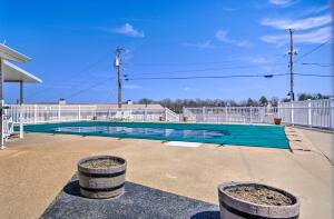 a swimming pool with two barrels in a parking lot at Osage Beach Resort Condo with Community Pool! in Osage Beach