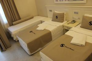 a hotel room with two beds and two tables at Savk Hotel in Alanya