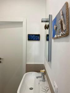 Baño blanco con lavabo y espejo en VillaGio, en Ceglie Messapica