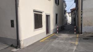 um beco vazio com um edifício branco e uma rua em Apartma Ela em Koper