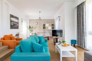 ein Wohnzimmer mit einem blauen Sofa und einem Tisch in der Unterkunft Felicia Home in Gouves