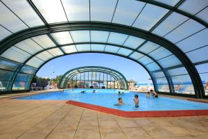 a large swimming pool with people in the water at Camping Paradis Le Grand' R in La Faute-sur-Mer