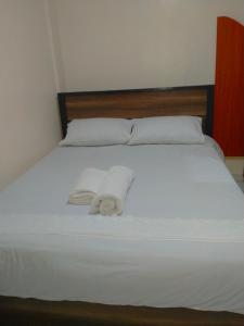 a bed with two white towels on top of it at Rovers Apartment in Nanyuki