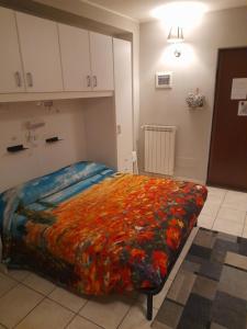 ein Schlafzimmer mit einem großen Bett mit einer bunten Decke in der Unterkunft Alloggio Turistico "FRANCESCA" in Viterbo