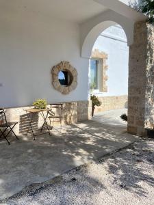 un patio con mesa, sillas y un arco en VillaGio, en Ceglie Messapica