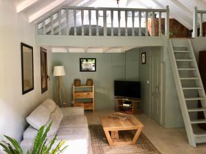 a living room with a loft bed and a couch at Bungalow Le Jasmin de Nuit in Les Abymes
