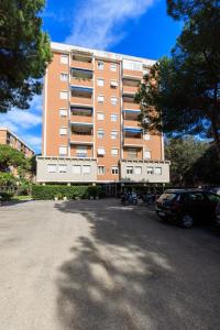 a large building with cars parked in front of it at L' essenziale in Livorno