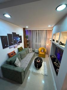 een woonkamer met een groene bank en een tv bij Family Apartment in Niš