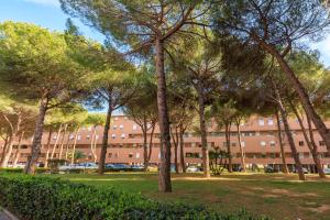 una fila di alberi di fronte a un grande edificio di L' essenziale a Livorno