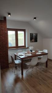 ein Esszimmer mit einem Holztisch und Stühlen in der Unterkunft Apartamenty Klangor in Mrągowo