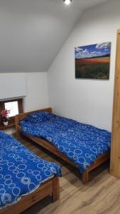 zwei Betten in einem Zimmer mit einem Bild an der Wand in der Unterkunft Apartamenty Klangor in Mrągowo