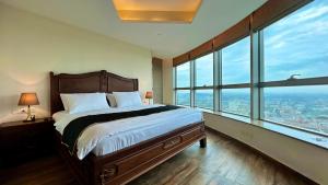 sypialnia z dużym łóżkiem i dużymi oknami w obiekcie Centaurus Apartment w mieście Islamabad