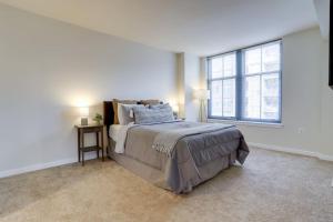 a white bedroom with a bed and a window at Fantastic 2 BR Condo At Pentagon City in Arlington