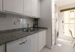 a white kitchen with a sink and a refrigerator at Bahía de Águilas in Águilas