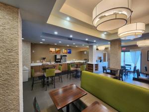 comedor y cocina con mesas y sillas en Comfort Suites New Orleans East, en Nueva Orleans