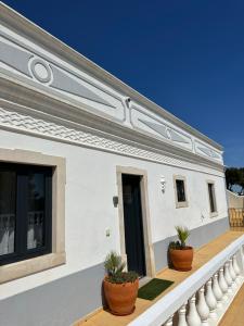Casa blanca con macetas en el balcón en Vila Mar Central, en Albufeira