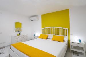 a bedroom with a bed with two yellow pillows at Casa Floriana Seaview in Capri +14 photos