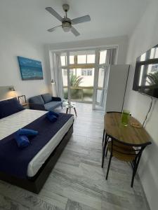 ein Schlafzimmer mit einem Bett, einem Tisch und einem Sofa in der Unterkunft PALMERAS 102 in Las Palmas de Gran Canaria