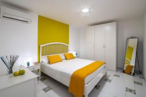 sypialnia z łóżkiem i żółtą ścianą w obiekcie My home Capri F w mieście Capri