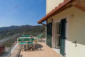 a balcony of a house with a table and chairs at CASA VACANZA IL PORTICO in Moneglia