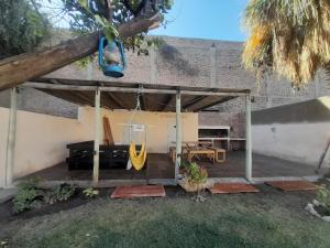 a patio with a swing and a hammock at Casa con piscina y parrillero in San Juan