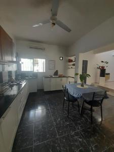 a kitchen with a table and chairs in a room at Casa con piscina y parrillero in San Juan
