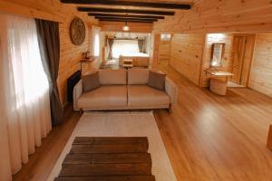 a living room with a couch and a bed in a cabin at Abant Yayla Dağevi in Dereceören