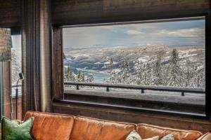 een raam met uitzicht op een besneeuwde berg bij New ap The Nest in Hafjell ski in out and fast Wifi in Øyer