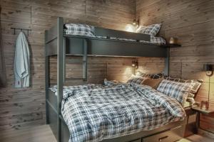 New ap The Nest in Hafjell ski in out and fast Wifi في أُيار: سريرين بطابقين في غرفة مع جدران خشبية
