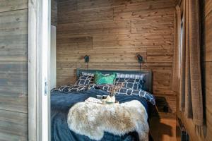 New ap The Nest in Hafjell ski in out and fast Wifi في أُيار: غرفة نوم مع سرير مع طاولة فراء faux