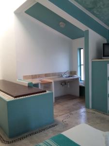 a room with a kitchen with a bed and a sink at Delphinus Inn in Santa Cruz Huatulco