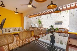 a living room with yellow walls and a table and chairs at 3CM-1 CASA COLONIAL DE 3 HABITACIONES CON PISCINA EN EL CORRALITO DE PIEDRA in Cartagena de Indias