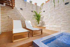 un patio con 2 sillas y una piscina en 3CM-1 CASA COLONIAL DE 3 HABITACIONES CON PISCINA EN EL CORRALITO DE PIEDRA, en Cartagena de Indias