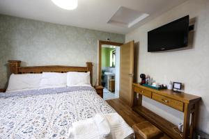 a bedroom with a bed and a television on the wall at Cloyfin B and B in Coleraine