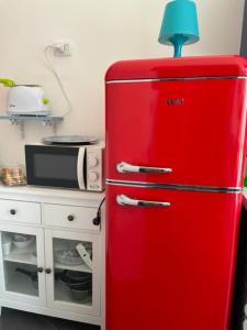 ナポリにあるLa porta accantoの電子レンジの横にあるキッチンの古い赤い冷蔵庫