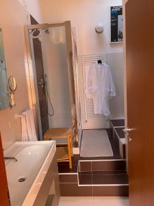 ein Badezimmer mit einem Waschbecken, einer Badewanne und einem weißen Hemd in der Unterkunft fabio strano in Spresiano