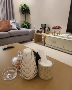 een woonkamer met een tafel met een vaas erop bij شقة صغيرة VIP حي الوادي غرفة وصالة in Riyad