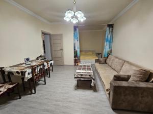 uma sala de estar com um sofá e mesas em Sunny Apartment close to Erebuni mall em Yerevan