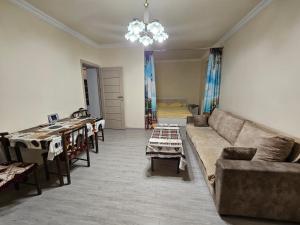 a living room with a couch and tables at Sunny Apartment close to Erebuni mall in Yerevan