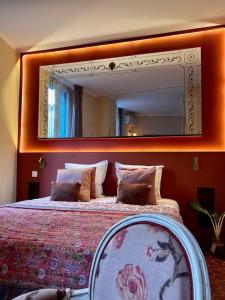 una camera da letto con un grande letto e un grande specchio di Studio terracotta a La Ciotat