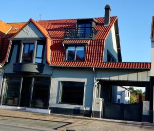 una casa con techo naranja y garaje en L 'étoile de Stella, en Stella-Plage