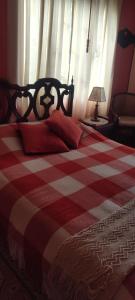 a bed with a red and white checkered blanket at El Pedregal Sopó in Sopó