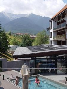 un groupe de personnes dans une piscine avec des montagnes dans l'établissement Bansko St Ivan Rilski Luxury Apartment 4 stars Free SPA & Mineral water, à Bansko