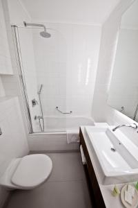 La salle de bains blanche est pourvue de toilettes et d'un lavabo. dans l'établissement Prima Vera, à Jérusalem