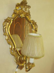 a gold mirror and a lamp with a lamp shade at Asteria Venetian Suite in Venice
