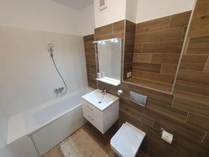 een badkamer met een toilet, een wastafel en een bad bij New Luxury Flat Near City Center in Timişoara