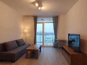 een woonkamer met een bank en een flatscreen-tv bij New Luxury Flat Near City Center in Timişoara