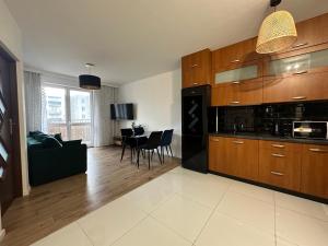 cocina con armarios de madera y sala de estar. en SDH 3 Radzymin comfortable apartment near Warsaw, en Radzymin